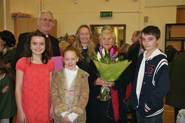 Archbishop Neill, Betty Neill and the Revd Sonia Gyles, Rector, are pictured with local children after they presented the Archbishop and Betty with gifts to mark their last official function in Sandford Parish Church, the dedication of the St Francis stained glass window. 