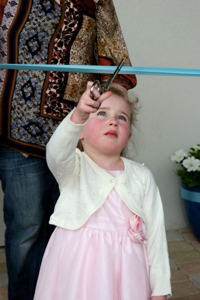 The youngest pupil of Powerscourt National School cuts the ribbon at the official opening and dedication of the new building. Both her parents and her grandparents attended the school. 