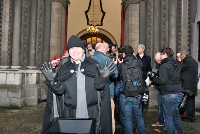 Vicar of St Ann’s, Dawson Street, the Revd David Gillespie, carries on collecting for the Black Santa Appeal while reporters, photographers and camera crews surround Archbishop Michael Jackson and Archbishop Diarmuid Martin who dropped in to support the sit out. The appeal continues until Christmas Eve with choirs joining the collectors each day. 