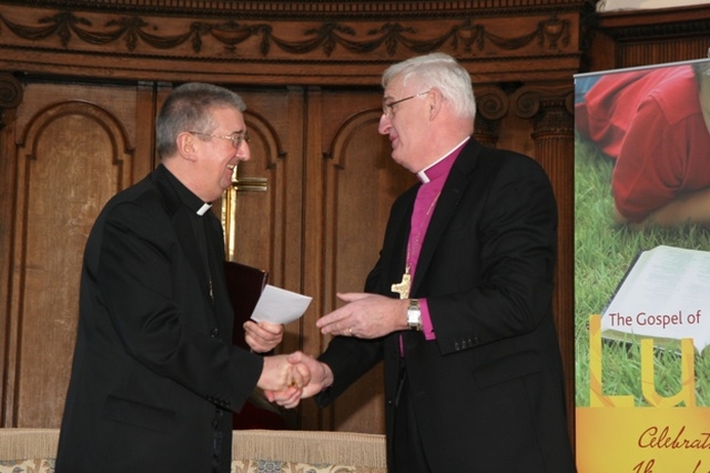 The Archbishop of Dublin, the Most Revd Dr John Neill (right) presents a cheque to the Most Revd Diarmiud Martin towards the costs of the Gospel of Luke which is jointly produced by the two Dioceses. The Gospel of Luke was launched in Trinity College Chapel.