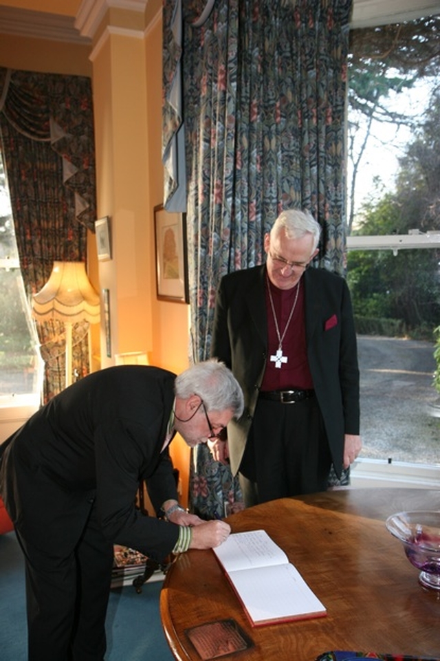 As the Archbishop of Dublin, the Most Revd Dr John Neill watches, the Ambassador of Belgium to Ireland, HE Robert Devriese signs the visitors book on his visit to the See House in Dublin.