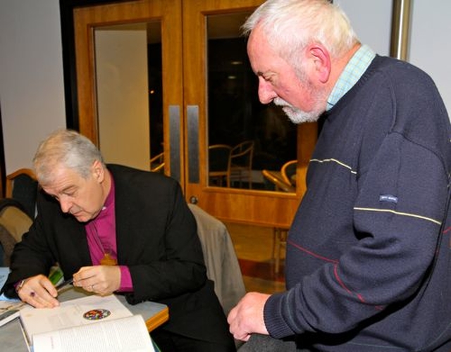 Archbishop Michael Jackson signs a copy of The Church of Ireland – An Illustrated History for Keith Dungan at the book’s Dublin launch in Church House. 