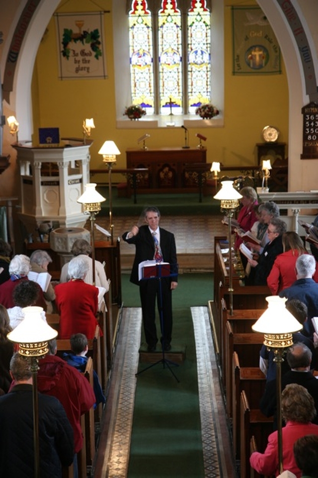 John Dexter conducting the congregation at a Songs of Praise service in Newcastle Parish Church, Co Wicklow. The songs of praise was being held to honor the contribution of five organists in the parishes of Newcastle, Newtownmountkennedy and Calary who collectively have over 240 years of service to the parishes.