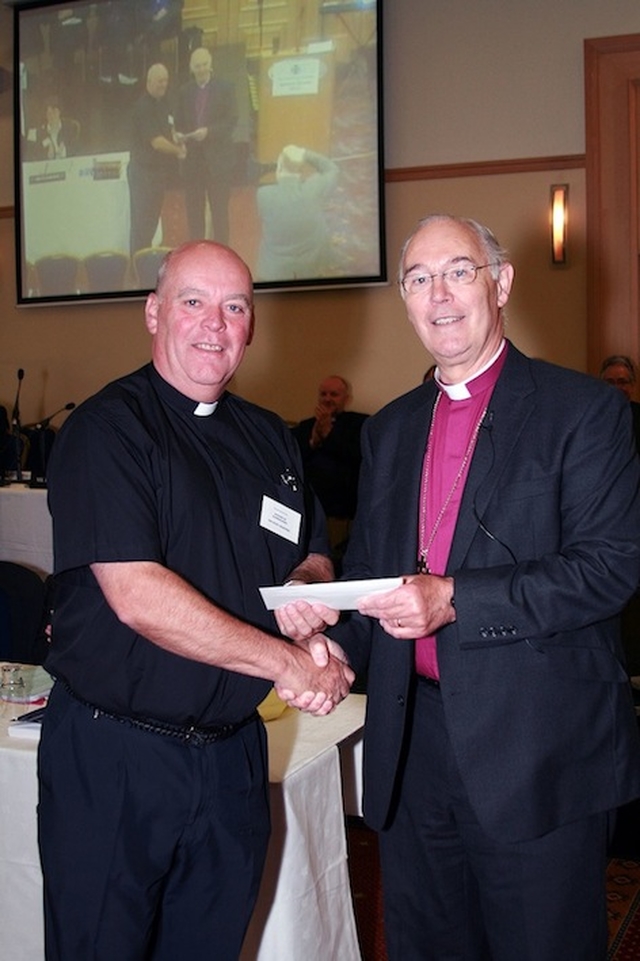Archbishop Alan Harper presenting the Ven Ricky Rountree, Archdeacon of Glendalough and Chairman of the Church Music Committee, with second prize in the 'other organisation printed publication' category of the General Synod communications awards for ‘Soundboard’ magazine. Photo: David Wynne.