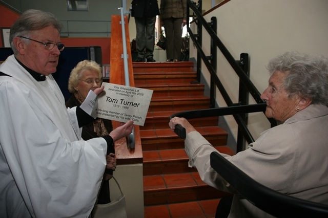 Pictured is the Revd Canon Desmond Sinnamon, Rector of Taney showing a plaque in honour of Tom Turner to his widow, Dolly. Dolly donated a chairlift to Taney parish in memory of her late husband. 