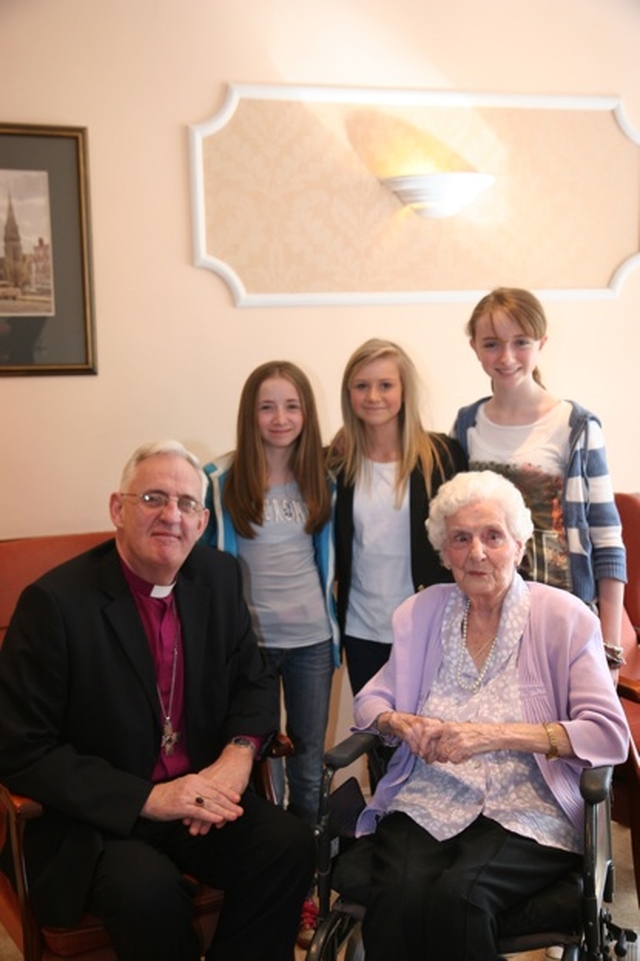 The Archbishop of Dublin, the Most Revd Dr John Neill and Olive Vaughan with three of Olive's great grandchildren on the occasion of Olive's 100th Birthday in Brabazon House.