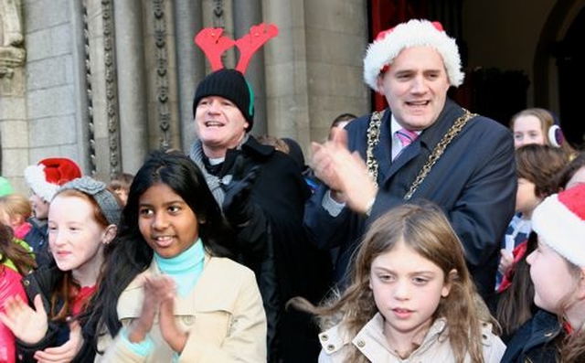 The Vicar of St Ann’s Church, Dawson Street, the Revd David Gillespie and the Lord Mayor of Dublin, Naoise Ó Muirí sing carols with the children of the Kildare Place School at the launch of the 2012 Black Santa Sit Out. 