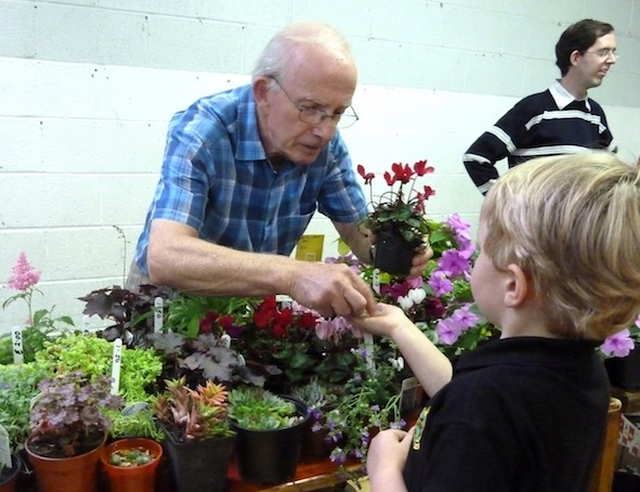 Bryan Wilkinson helps a young customer at St. Mary's Autumn Fayre. Photo: Ted Morrissey