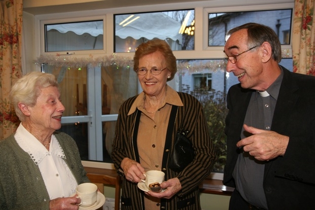 Pictured at the Brabazon House Carol Service are (left to right) Joan Mahony, Elsie Nelson and the Revd Harry Lew (Chaplain to the House).