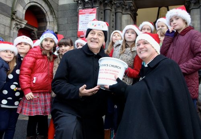 Archbishop Michael Jackson and Canon David Gillespie with members of Taney Parish Junior Choir at the launch of the 2014 Black Santa Sit Out at St Ann’s, Dawson Street. 