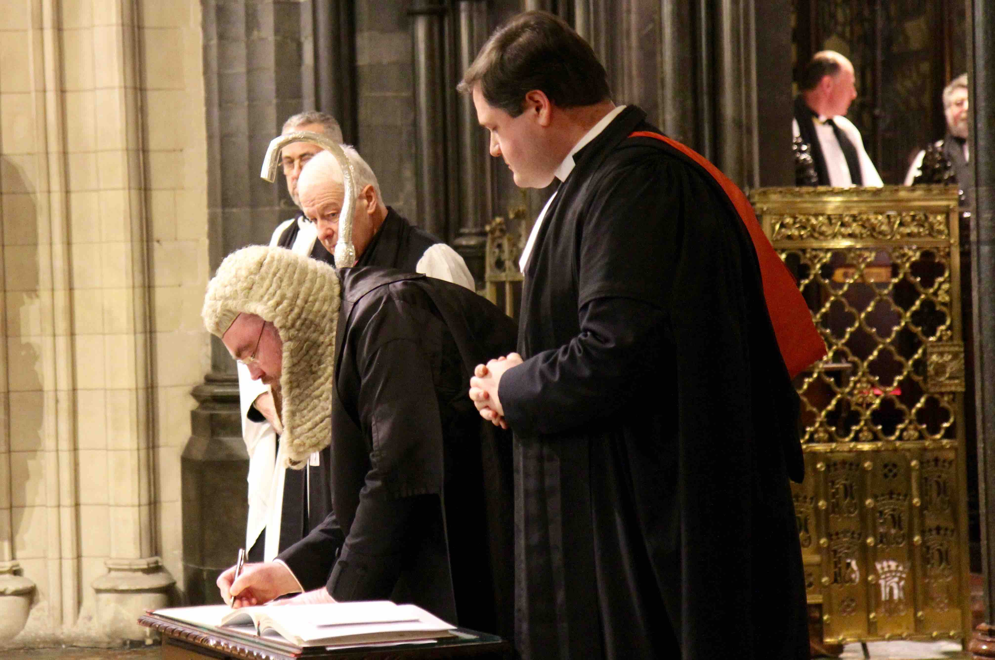 Ciarán Toland SC signs the declaration during his installation as Diocesan Chancellor at Christ Church Cathedral. He is watched by the Revd Stephen Farrell, Archbishop Michael Jackson and Dean Dermot Dunne.