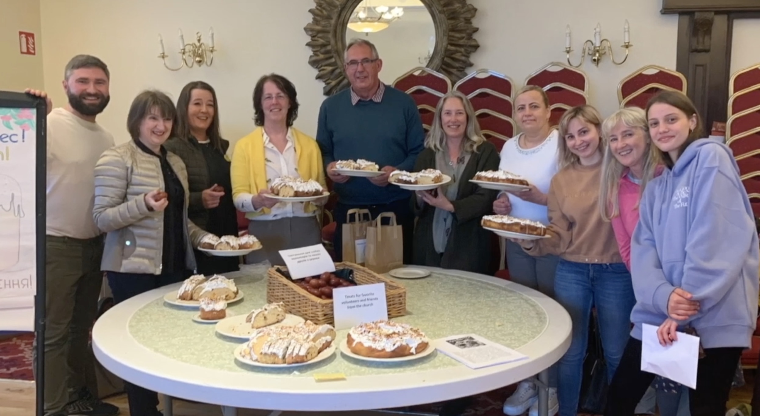 The Revd Trevor Stevenson with some of the people from Ukraine and the cake baked in Crinken.