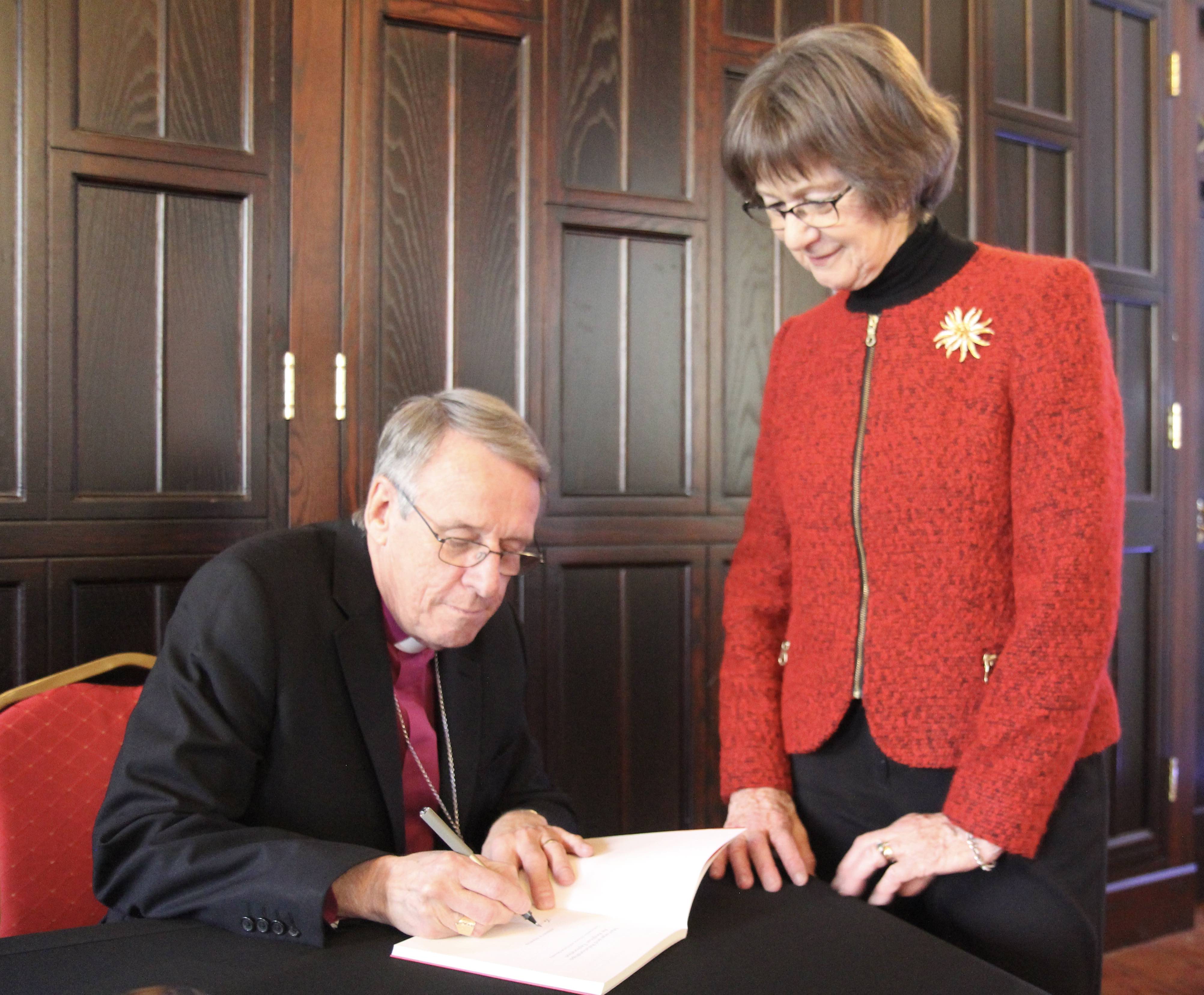 Bishop Kenneth Kearon signs a copy of his book for Gillian Kingston.