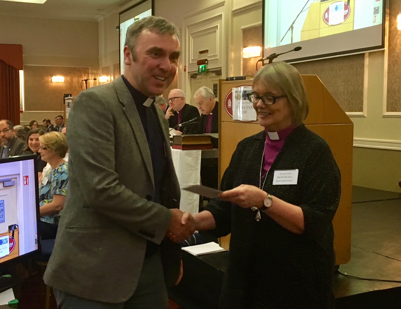 The Revd Rob Clements receiving his Communications Competition prize from Bishop Pat Storey.