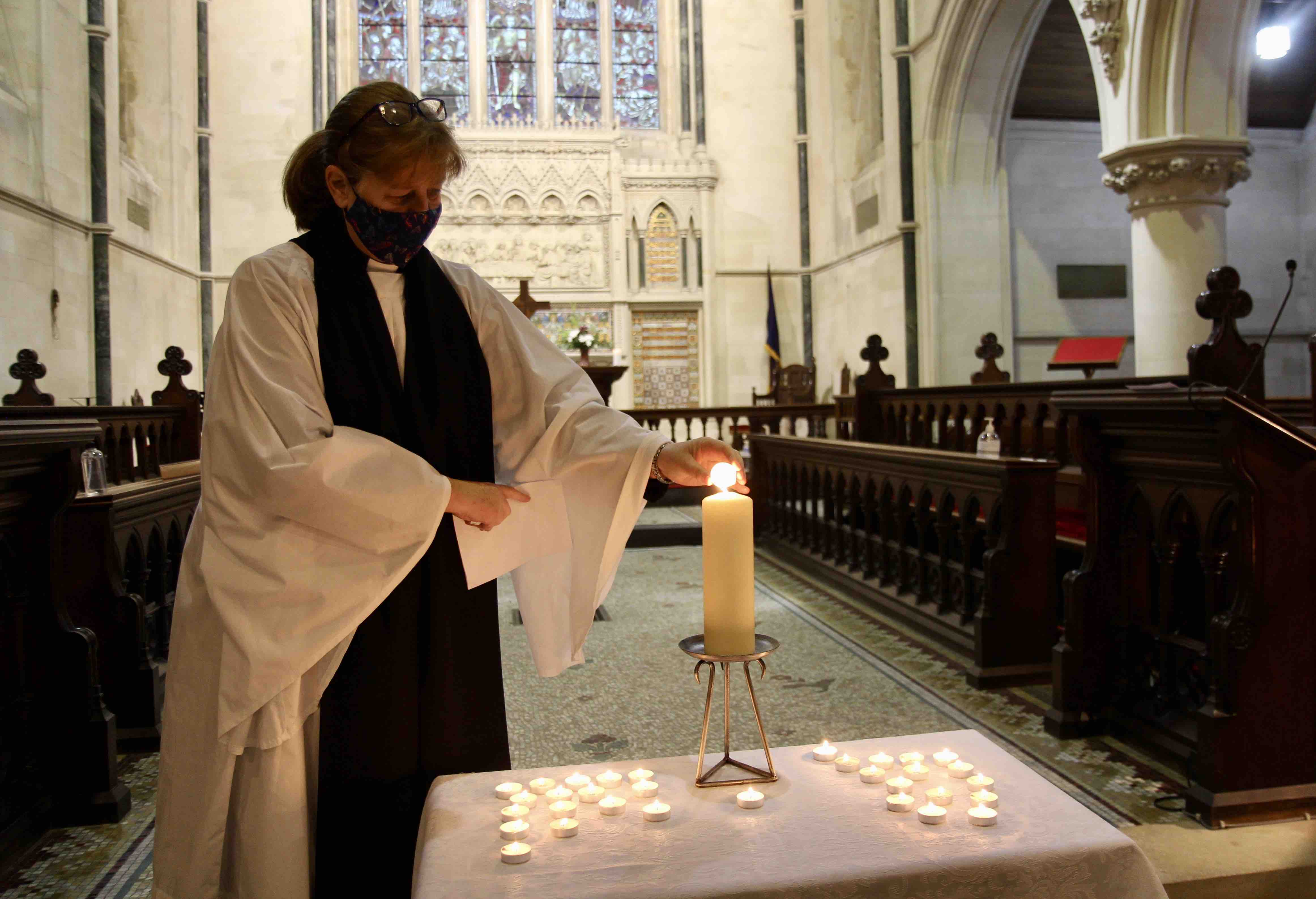 The Revd Suzanne Harris lighting a candle during the Liturgy of Remembrance at the Service of Light