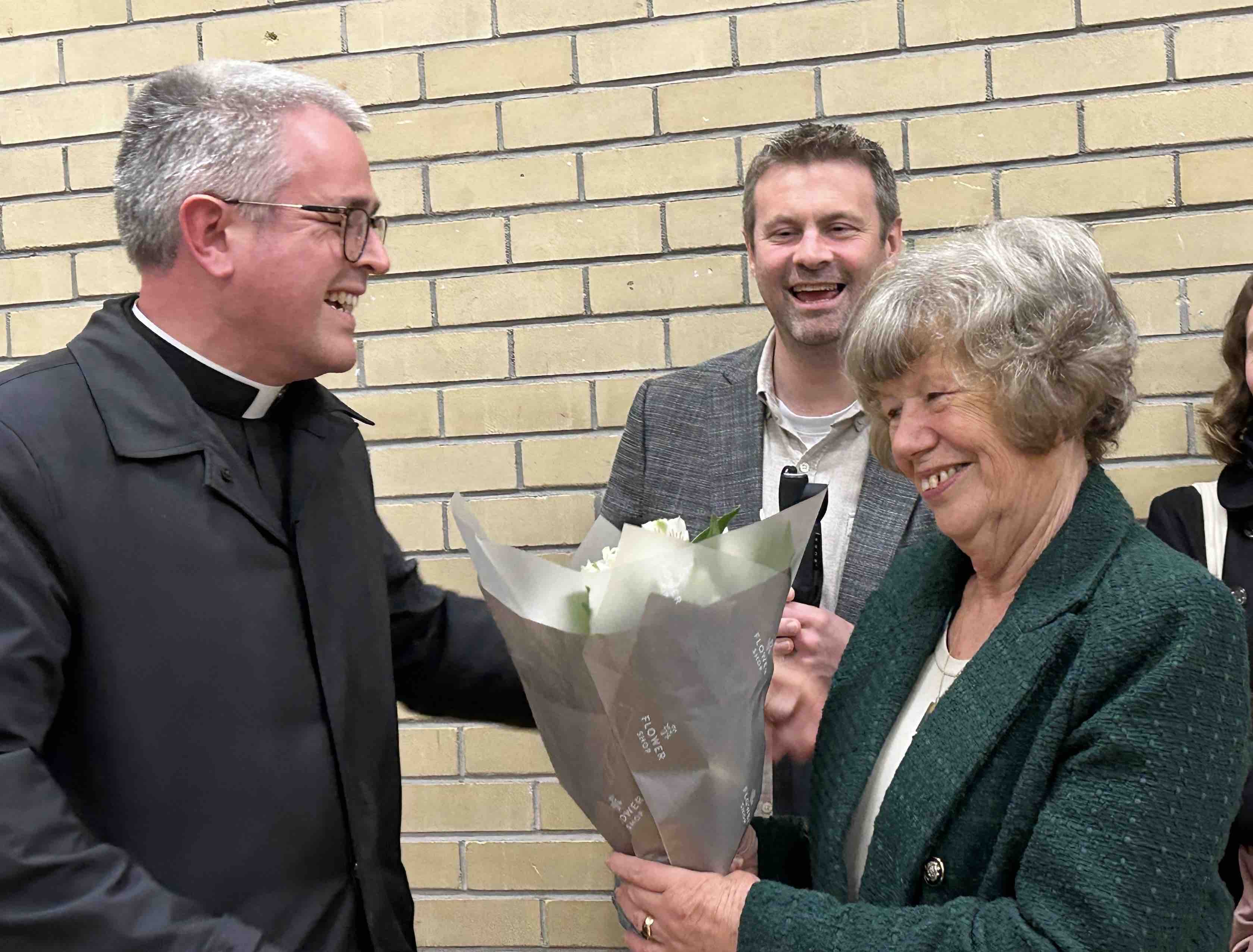 Canon Paul Arbuthnot presents Anne O'Regan with flowers for her birthday.