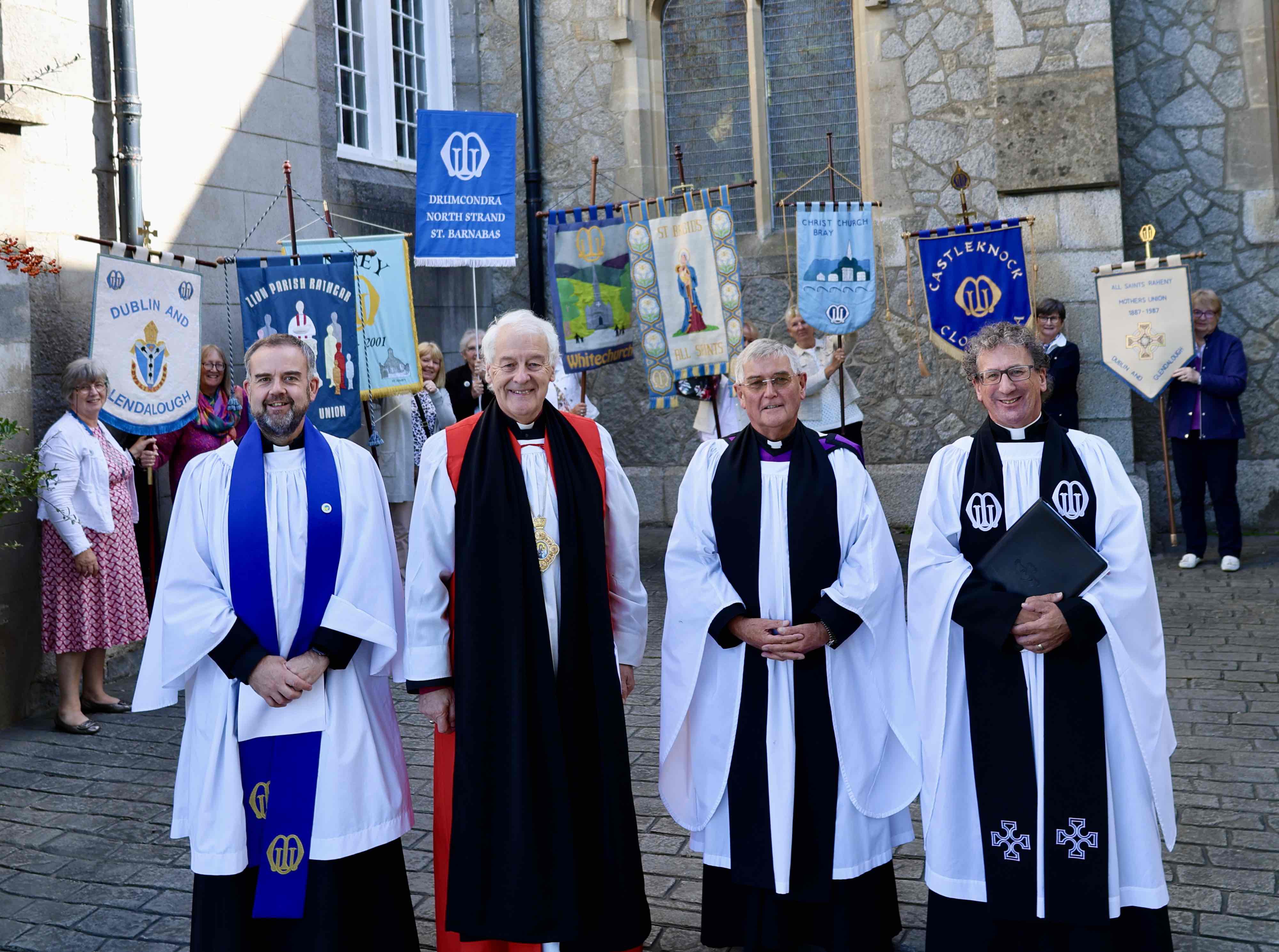 The Revd Colin McConaghie, Diocesan Chaplain, Archbishop Michael Jackson, the Revd Nigel Pierpoint and the Revd Alistair Doyle, All Ireland Chaplain with branch banners and their bearers in the background.