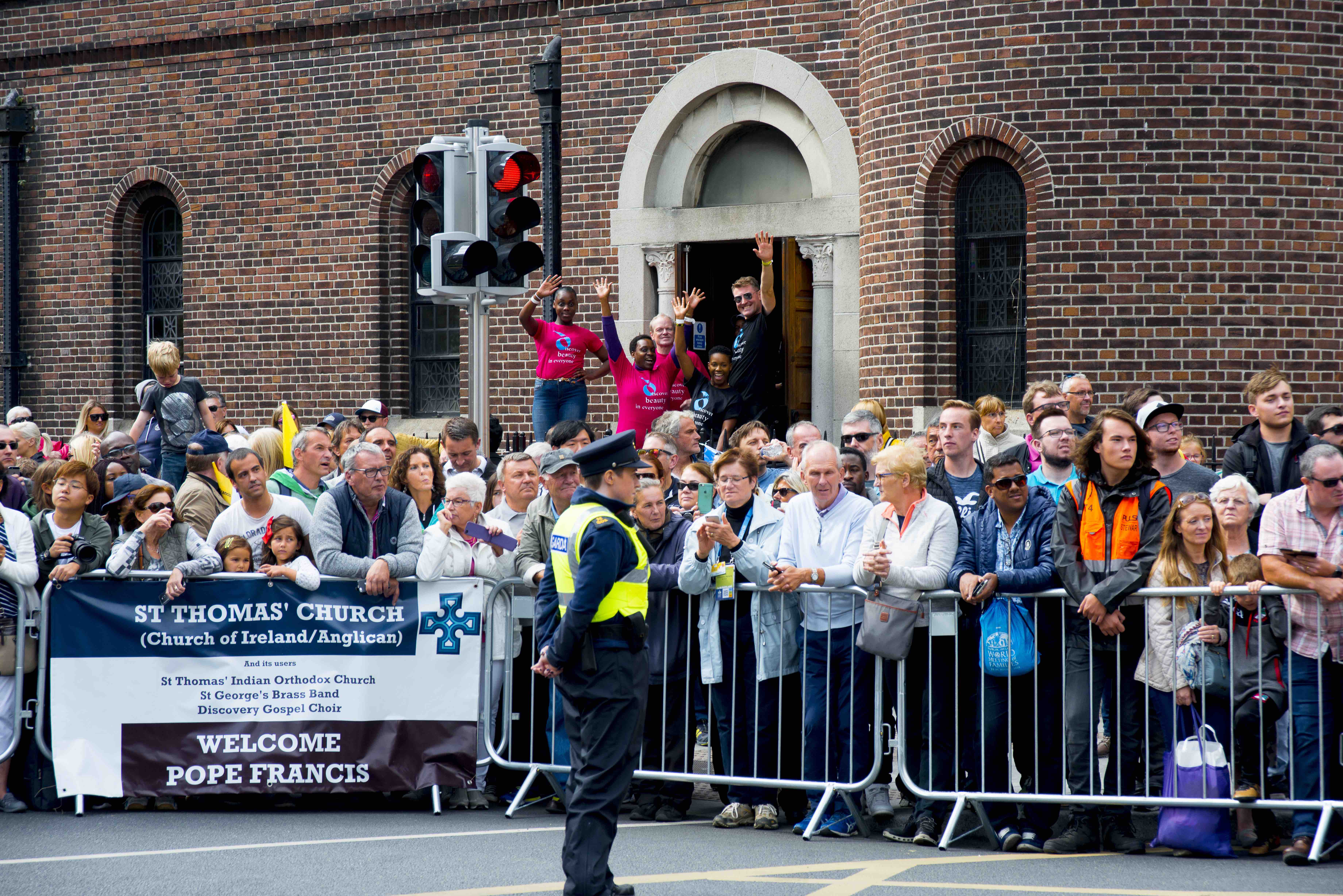 Crowds gather outside St Thomas's Church to await Pope Francis, including members of the groups who use the church.