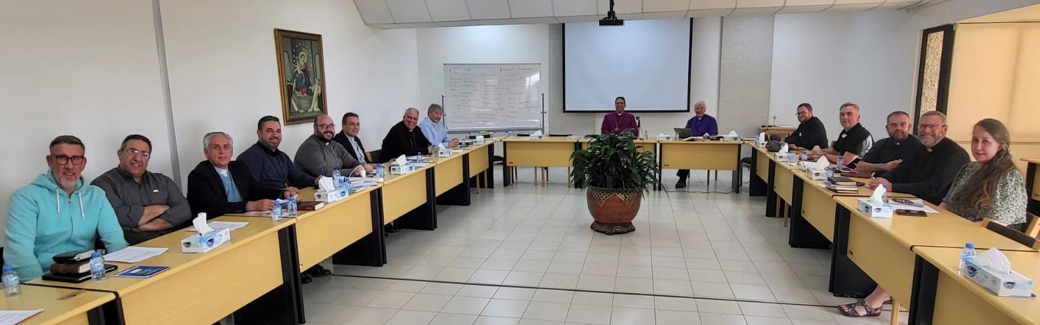 Clergy gathered around the table of learning.