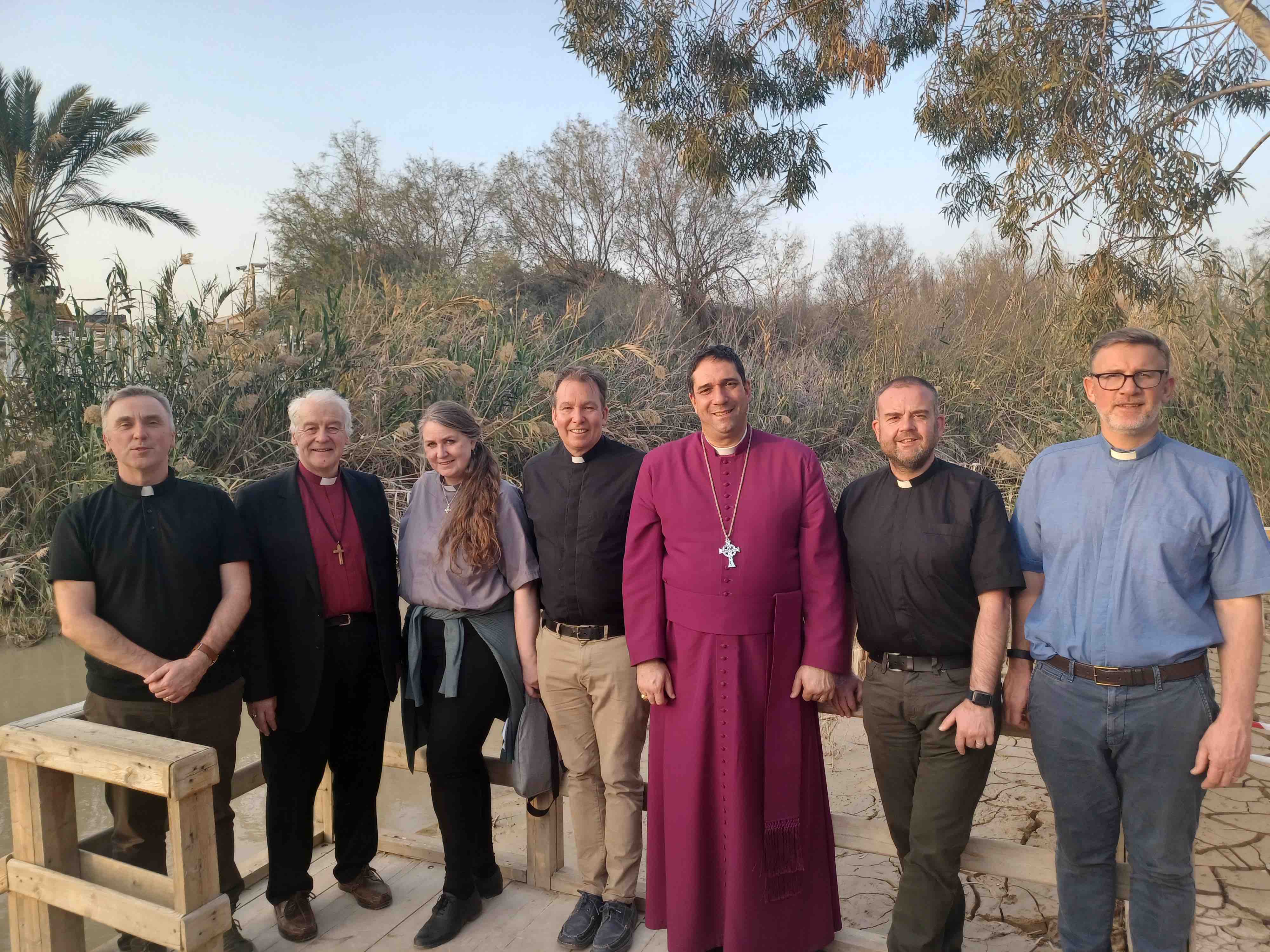 The Revd Rob Clements, Archbishop Michael Jackson, the Revd Ása Bjork Ólafsdóttir, Canon Peter Campion, Archbishop Hosam Naoum, the Revd Colin McConaghie and the Revd Rob Jones by the River Jordan.