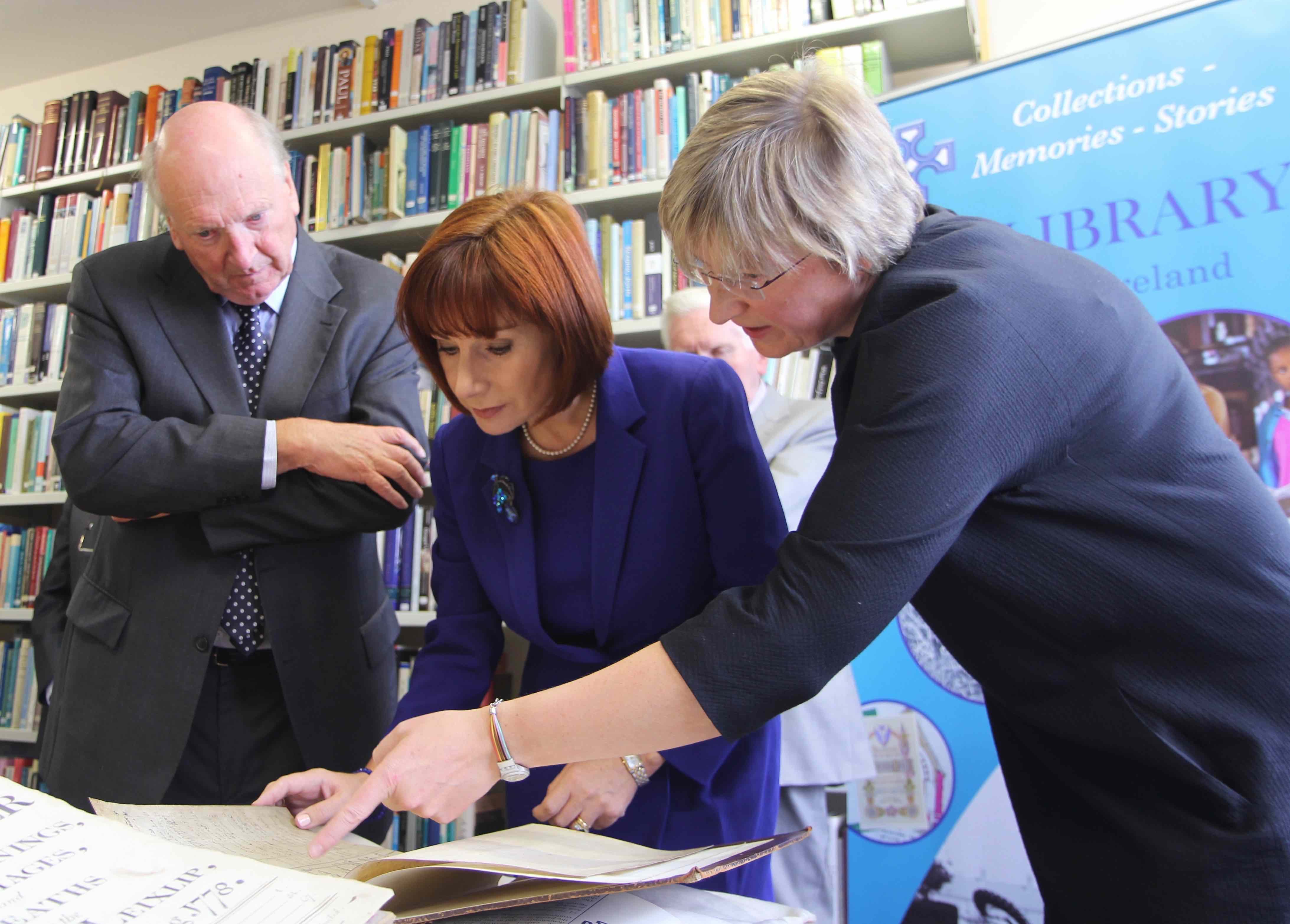 Minister for Culture, Heritage and the Gaeltacht Josepha Madigan viewing some of the RCB Library's records with the Librarian and Archivist, Dr Susan Hood, and Dr Michael Webb, Chairperson of the Library and Archives Committee, during the Minister's informal visit to the Library to announce a capital grant for the digitisation of Church of Ireland parish registers.